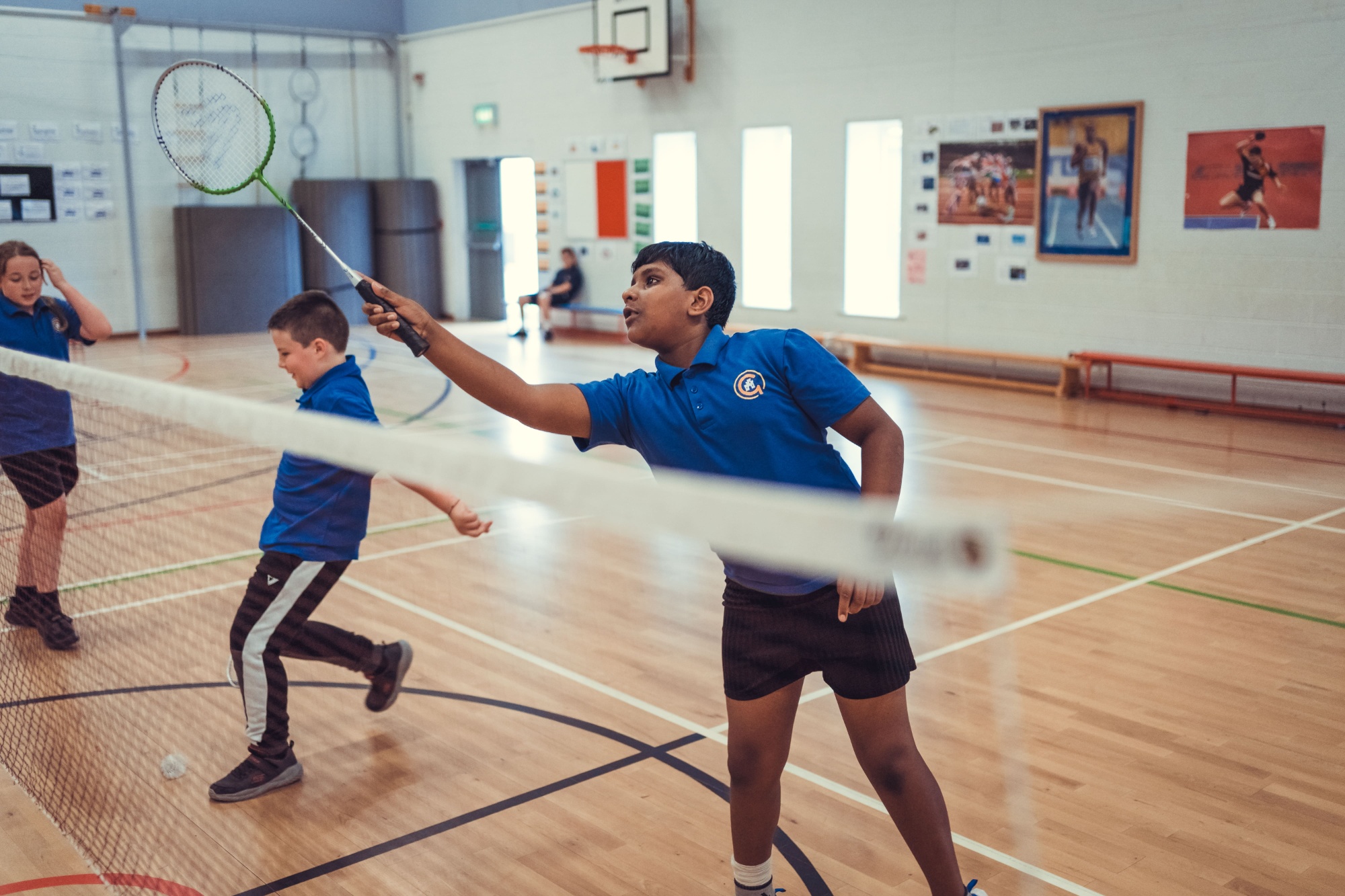 Children playing badminton in sports hall